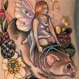 Neo-Traditional leg tattoo of a fairy riding a mouse, surrounded by blackberries and yellow flowers, designed by Lacey Griffiths at House of Wolves Tattoo, Geelong