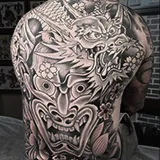 Large back-piece tattoo in progress, showing the outline and shading of a Hannya mask and dragon head, crafted by Shannon Hodgkin at House of Wolves Tattoo, Geelong